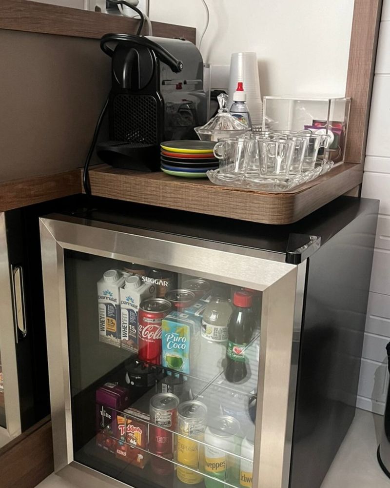 Cantinho do café, com cafeteira, xícaras e frigobar